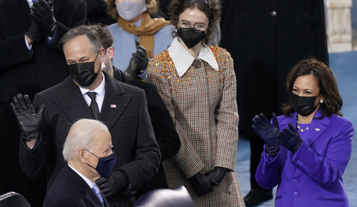 FILE - Ella Emhoff, background center, stands with her stepmother, Vice President-elect Kamala Harris, right, and her father Doug Emhoff, left, as President-elect Joe Biden arrives for the 59th Presidential Inauguration at the U.S. Capitol in Washington, on, Jan. 20, 2021. The designers at Proenza Schouler decided to dress Ella Emhoff in a couple of coats (plus a pantsuit) for her modeling debut in their new collection, unveiled Thursday for New York Fashion Week. (AP Photo/Carolyn Kaster, File)