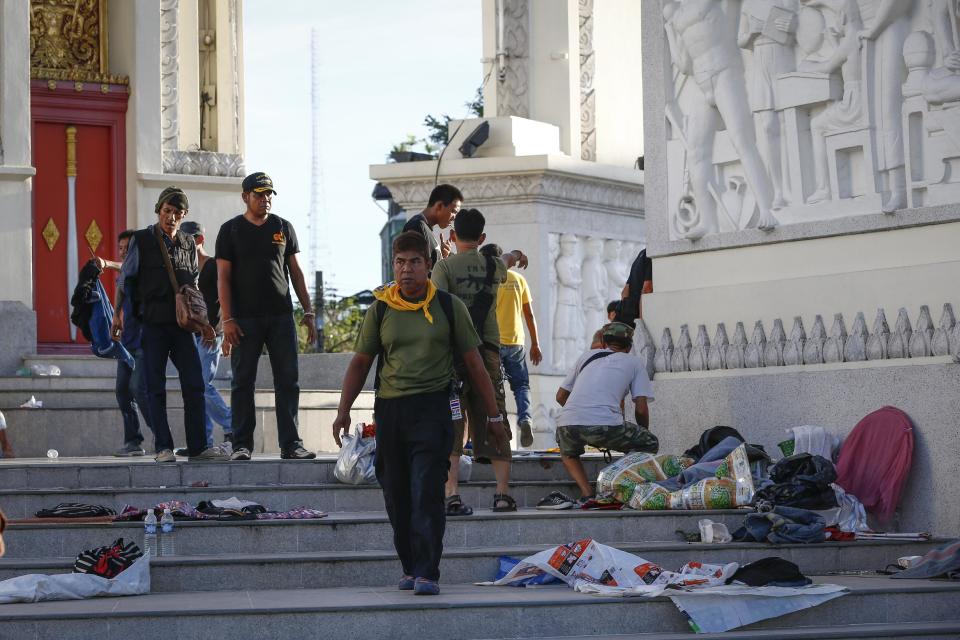 Volunteers from anti-government protesters clean up after an overnight shooting attack at Democracy Monument in Bangkok, Thailand, Thursday, May 15, 2014. Explosions and the overnight shooting attack on opposition demonstrators in Thailand’s capital killed at least two people Thursday, the latest violence to hit Bangkok since protesters launched a campaign to oust the government six months ago. (AP Photo/Vincent Thian)