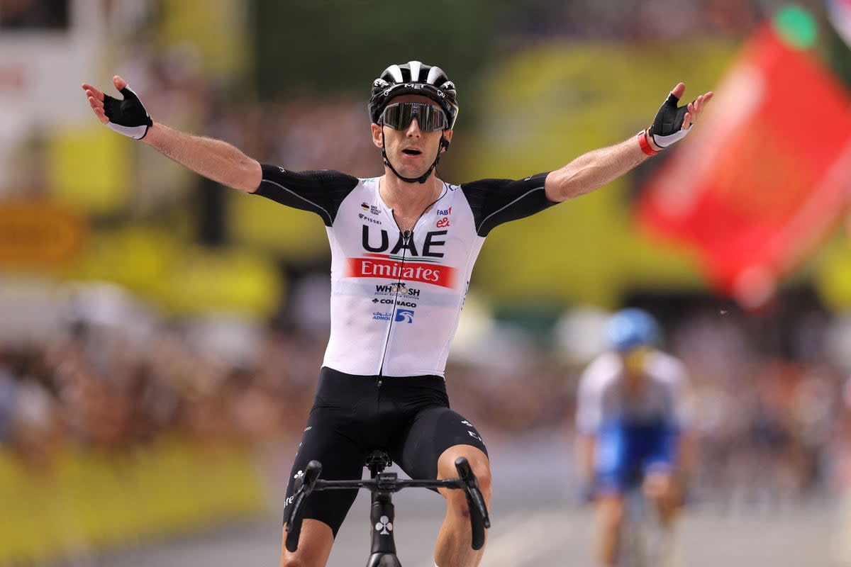 Adam Yates celebrates claiming victory and the yellow jersey (AFP via Getty Images)