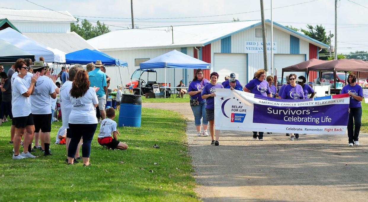 Cancer survivors walk the Survivor Lap during Relay for Life at the Ashland County Fairgrounds in 2021 as Relay teams cheer them on. LIZ A. HOSFELD/FOR TIMES-GAZETTE.COM