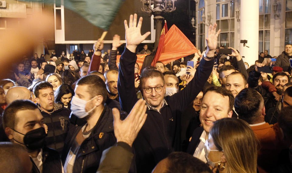 Hristijan Mickoski, center, leader of the opposition VMRO-DPMNE party, is greeted by supporters during celebration of the victory on the local elections, at the party headquarters in Skopje, North Macedonia, late Sunday, Oct. 31, 2021. North Macedonia's Prime Minister Zoran Zaev announced his resignation as prime minister and leader of Social-democratic Union after oppositional center-right coalition won a landslide victory on local elections. (AP Photo/Boris Grdanoski)