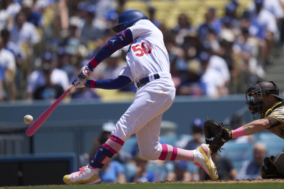 Los Angeles Dodgers' Mookie Betts (50) hits a home run on a fly ball to center field bringing home Miguel Rojas during the fourth inning of a baseball game against the San Diego Padres, Sunday, May 14, 2023, in Los Angeles. (AP Photo/Allison Dinner)