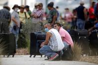 Migrants seeking for a U.S. work visa are seen waiting in a park of downtown of Monterrey