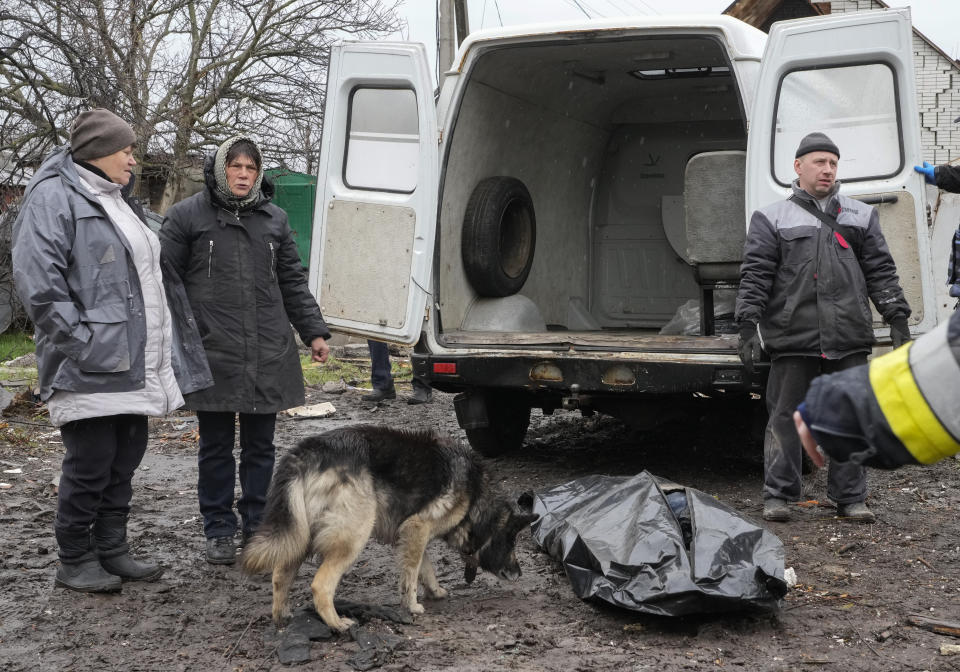 Relatives stand by a body of a civilian killed in a Russian air raid at the beginning of the Russia-Ukraine war is being recovered, in Borodyanka close to Kyiv, Ukraine, Saturday, Apr. 9, 2022. Borodyanka was occupied by the Russian troops and freed in a month by the Ukrainian army, allowing emergency workers to search civilian bodies under the ruins. (AP Photo/Efrem Lukatsky)