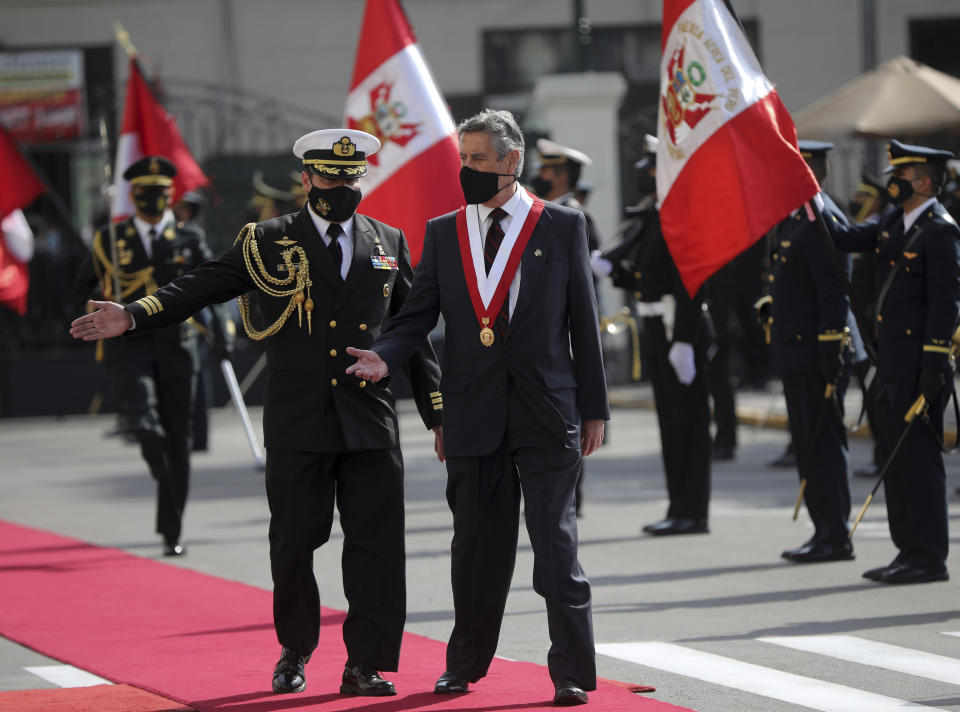 Francisco Sagasti is shown the way by his military escort as he arrives to be sworn-in as the new, interim president at Congress in Lima, Peru, Tuesday, Nov. 17, 2020. Sagasti's appointment marks a tumultuous week in which thousands took to the streets outraged by Congress' decision to oust popular ex-President Martín Vizcarra. (AP Photo/Rodrigo Abd)