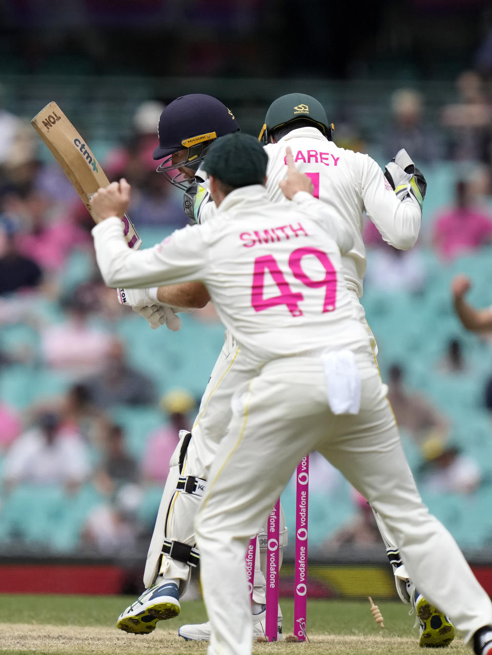 England's Dawid Malan, back, is bowled by Australia's Nathan Lyon during the fifth day of their Ashes cricket test match in Sydney, Sunday, Jan. 9, 2022. (AP Photo/Rick Rycroft)