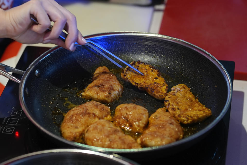 Chef Mika Leon cooks cultivated chicken at a pop-up tasting for "lab-grown" meat produced by California-based Upside Foods, Thursday, June 27, 2024, in Miami. As Florida's ban on lab-grown meat is set to go into effect next week, one manufacturer hosted a tasting party, serving up cultivated chicken tostadas to dozens of attendees on a rooftop in Miami's Wynwood neighborhood. (AP Photo/Rebecca Blackwell)