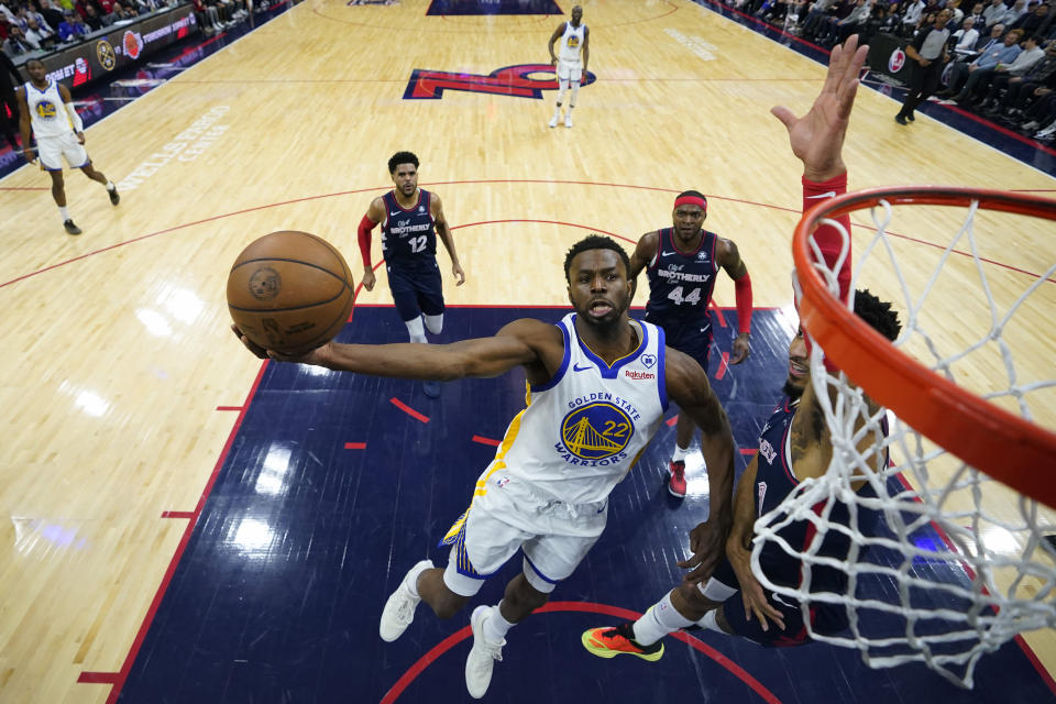 Golden State Warriors' Andrew Wiggins, left, goes up for a shot against Philadelphia 76ers' KJ Martin during the first half of an NBA basketball game, Wednesday, Feb. 7, 2024, in Philadelphia. (AP Photo/Matt Slocum)