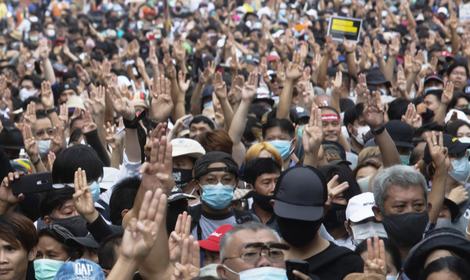 Anti-government protesters raise a three-fingered salute, a symbol of resistance, as they march from Democracy Monument to government house in Bangkok, Thailand, Wednesday, Oct. 14, 2020. Anti-government protesters began gathering Wednesday for a planned rally at Bangkok's Democracy Monument being held on the anniversary of a 1973 popular uprising that led to the ousting of a military dictatorship, amid a heavy police presence and fear of clashes with political opponents. (AP Photo/Sakchai Lalit)