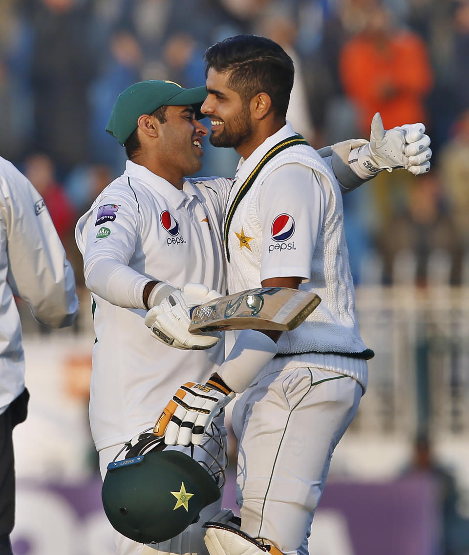 Pakistani batman Babar Azam, right, is congratulated by teammate Amid Ali after completing his century during the fifth-day of the 1st cricket test match between Pakistan and Sri Lanka, in Rawalpindi, Pakistan, Sunday, Dec. 15, 2019. (AP Photo/Anjum Naveed)