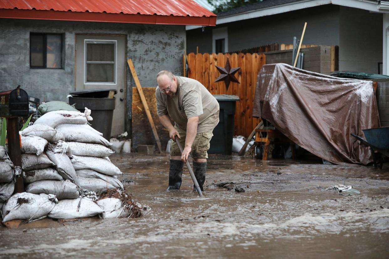 A resident shovels back floodwater as monsoon rains fell on the Museum Fire burn area causing flooding from the Paradise Wash in east Flagstaff, Ariz., on Wednesday, July 14, 2021. The threat of flash flooding will remain through next week,