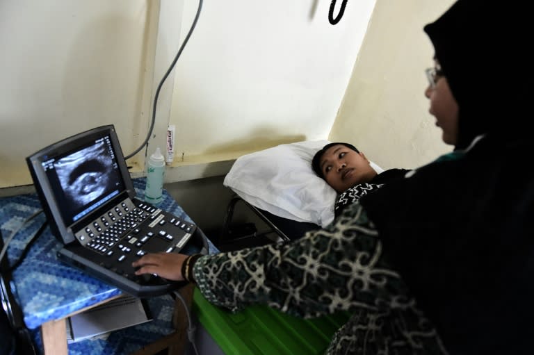 A doctor performs an ultrasound on an pregnant woman from a former logging family at a non-profit health clinic in Sukadana, West Kalimantan province, Borneo