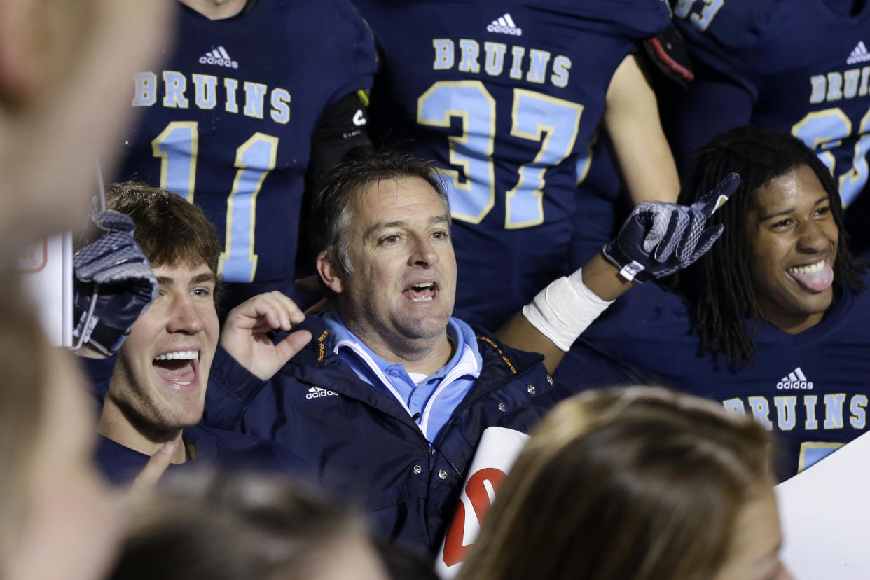 Pulaski Academy coach Kevin Kelley, center, celebrates with his team after the Arkansas Class 5A High School Championship football game on Dec. 6, 2014. (AP)