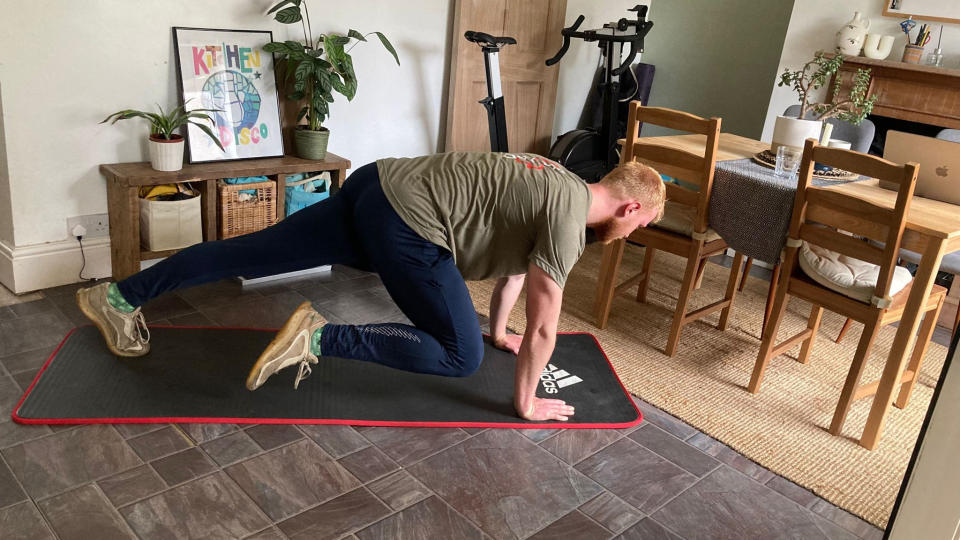 Man performing mountain climbers at home