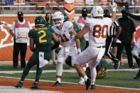 Texas' Sam Ehlinger (11) runs into the end zone for a touchdown against Baylor's Terrel Bernard (2) during the second half of an NCAA college football game in Austin, Texas, Saturday, Oct. 24, 2020. (AP Photo/Chuck Burton)