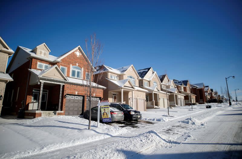 FILE PHOTO: A real estate for sale sign stands in front of a row of houses in East Gwillimbury