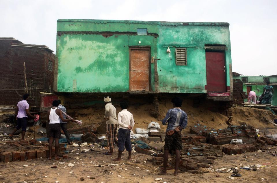 Fishermen clear debris from their damaged houses after Cyclone Phailin hit Puri