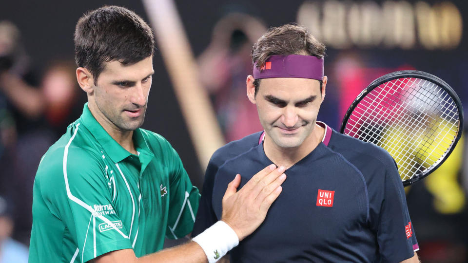 TOPSHOT - Serbia's Novak Djokovic (L) pats Switzerland's Roger Federer after his victory during their men's singles semi-final match on day eleven of the Australian Open tennis tournament in Melbourne on January 30, 2020. (Photo by DAVID GRAY / AFP) / IMAGE RESTRICTED TO EDITORIAL USE - STRICTLY NO COMMERCIAL USE (Photo by DAVID GRAY/AFP via Getty Images)