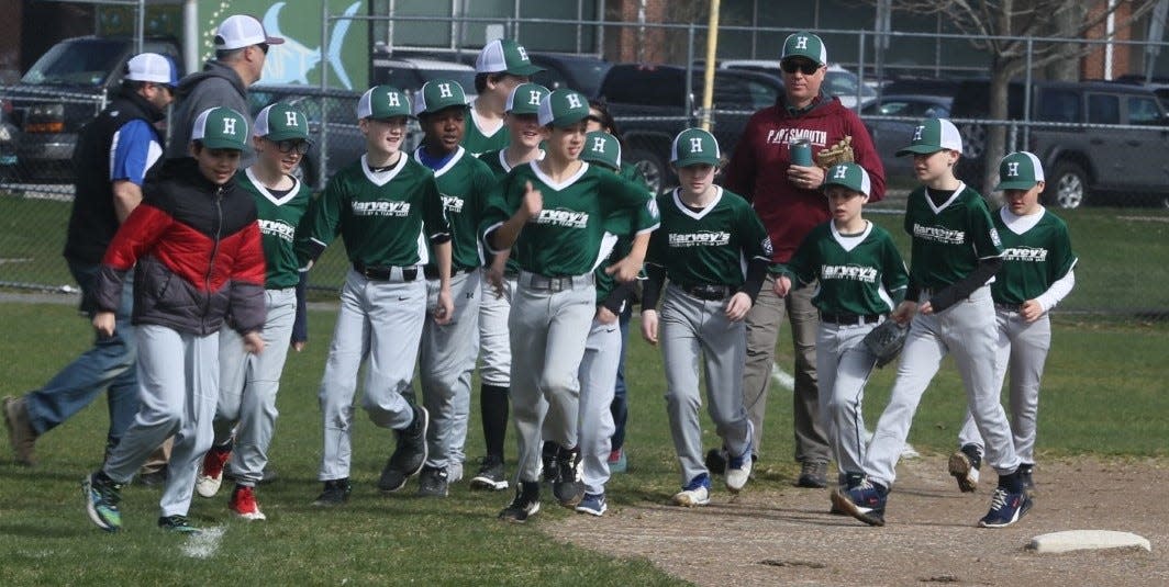 Members of Harvey's Embroidery take to the field during Portsmouth Little League Opening Day ceremonies on Saturday at Leary Field.