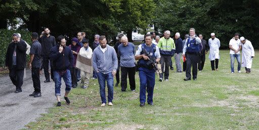 Witnesses being escorted away from one of the mosques by armed police (AP)