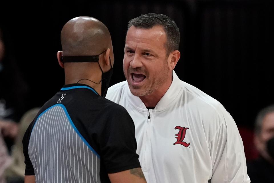 Louisville head coach Jeff Walz, right, speaks with an official during the first half of an NCAA college basketball game against North Carolina State in Raleigh, N.C., Thursday, Jan. 20, 2022. (AP Photo/Gerry Broome)