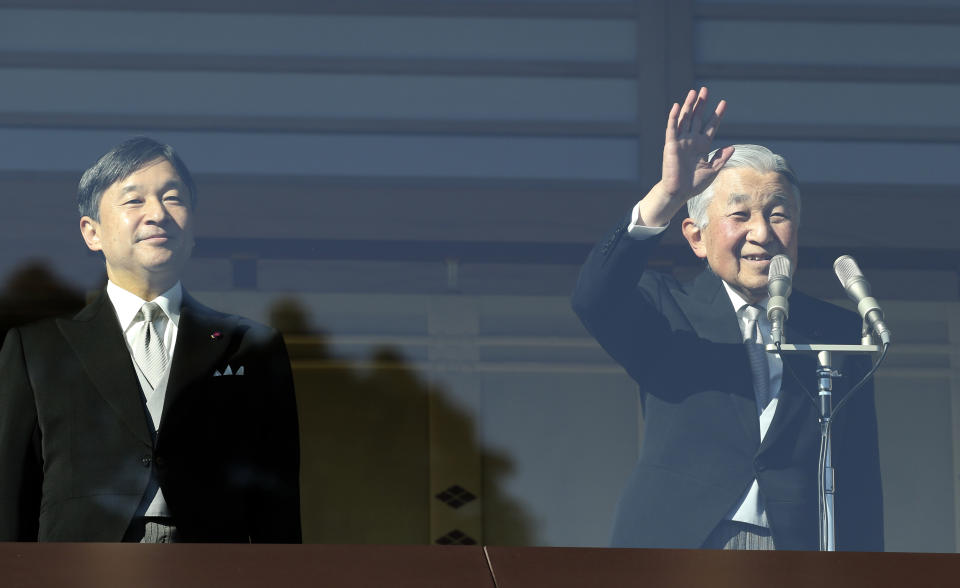 FILE - In this Dec. 23, 2017, file photo, Japan's Emperor Akihito, right, waves to well-wishers, with Crown Prince Naruhito, left, on the bullet-proofed balcony of the Imperial Palace in Tokyo. Naruhito, Japan’s future new emperor is a musician and historian who is expected to bring a global perspective to an ancient institution when he ascends the Chrysanthemum Throne on Wednesday, May 1, 2019. (AP Photo/Koji Sasahara, File)