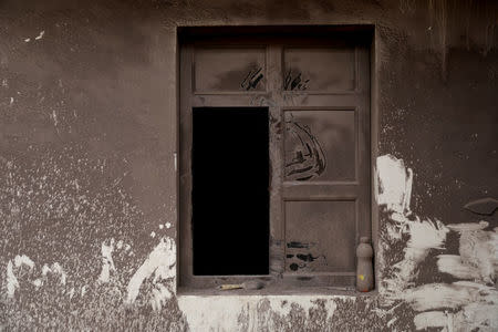 A window of a house is covered with ash after the eruption of the Fuego volcano at San Miguel Los Lotes in Escuintla, Guatemala, June 8, 2018. REUTERS/Carlos Jasso