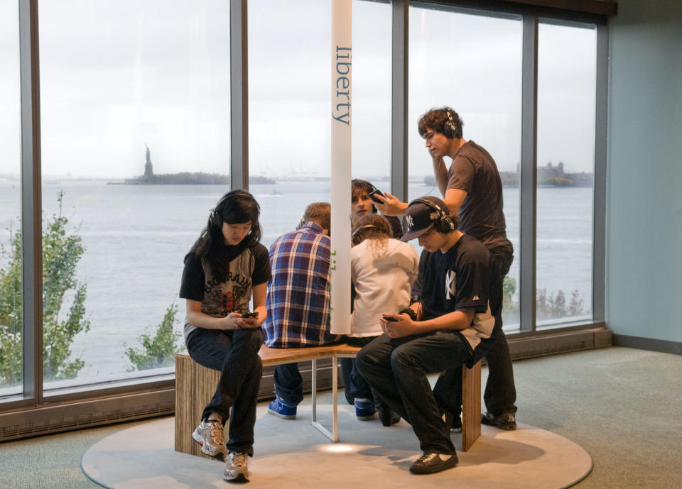 In this 2009 photo released by the Museum of Jewish Heritage-A Living Memorial to the Holocaust, young visitors at the museum listen to a sound installation called "Voices of Liberty," in which Holocaust survivors, refugees and others discuss why they chose to make the U.S. their home. The museum is located in Lower Manhattan and offers a view of the Statue of Liberty through its picture windows, one of many different vantage points around the city for seeing the statue. (AP Photo/Museum of Jewish Heritage-A Living Memorial to the Holocaust, Melanie Einzig)