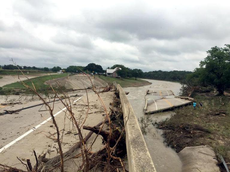 This May 24, 2015 handout photo provided by the Blanco Police Department in Blanco, Texas shows the bridge on Rte 165 spanning the Blanco River that was washed away by flash flooding caused by torrential downpours