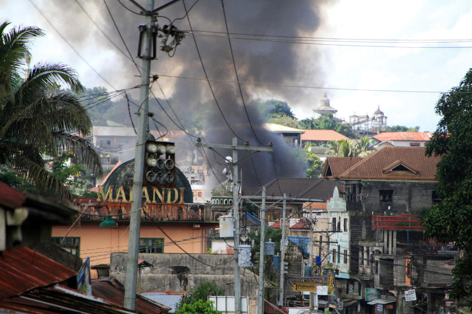 <p>Smoke rises from burning houses following an air strike at Maute rebels stronghold as fighting between Islamist militants and government forces continues in Marawi city, Mindanao island, southern Philippines on May 30, 2017. (Richel Umel/EPA) </p>