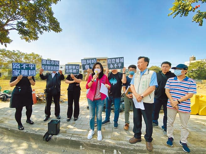 台南市議員林燕祝（前排右三）昨天到永康區東橋七路會勘柴頭港溪D幹線排水工程施工進度，多位民眾高舉標語表達無奈心聲。（曹婷婷攝）