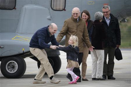 Nicolas Henin (L), former French hostage and journalist, is greeted by his family moments after a transfer by helicopter from Evreux to the military airbase in Villacoulbay, near Paris, April 20, 2014. REUTERS/Philippe Wojazer