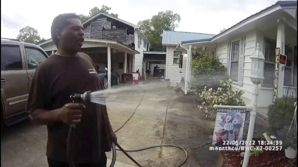 This image captured from bodycam video released by the Childersburg (Ala.) Police Department and provided by attorney Harry Daniels shows Michael Jennings, left, in custody in Childersburg, Ala., on Sunday, May 22, 2022. Jennings was helping out a friend by watering flowers when officers showed up and placed him under arrest within moments. (Childersburg Police Department via AP)