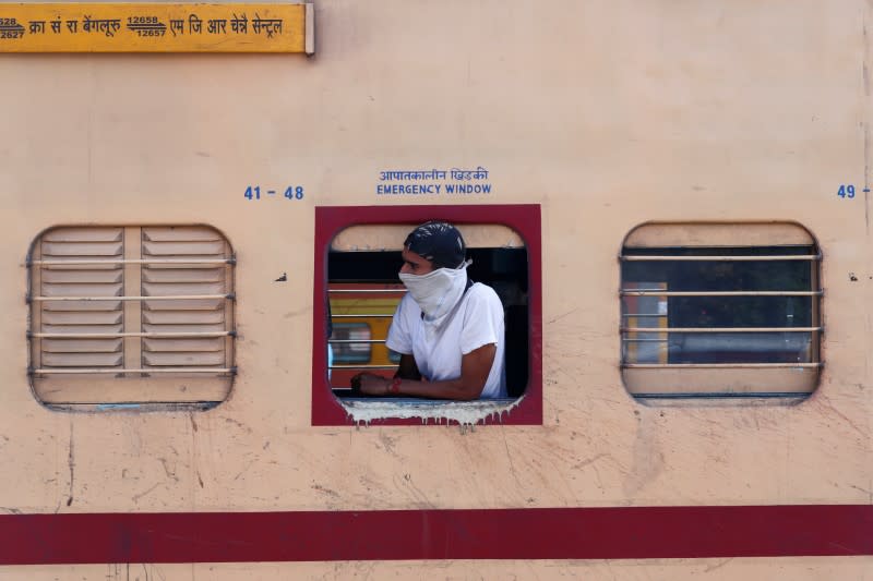 A man with his face covered looks out from a train during lockdown by the authorities to limit the spreading of coronavirus disease (COVID-19), in New Delhi