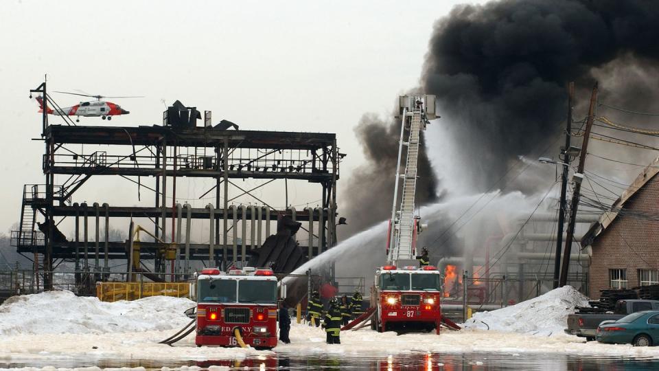 Fire fighters still use foam to put out petroleum fires like this one at an ExxonMobil petroleum storage facility in 2003 in New York City. The foam can contain polyfluoroalkyl substances, or PFAS, which are known as forever chemicals because they don’t break down easily and have contaminated ground water. (Photo by Mike Hvozda/USCG/Getty Images)