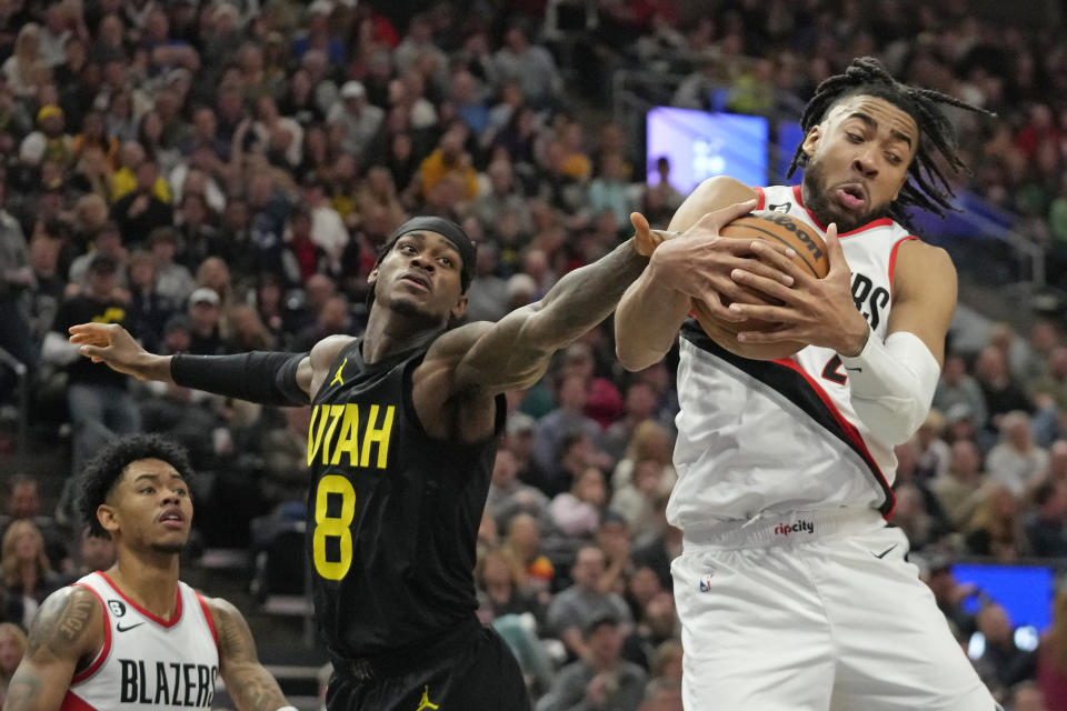 Portland Trail Blazers forward Trendon Watford, right, pulls down a rebound as Utah Jazz forward Jarred Vanderbilt (8) defends during the second half of an NBA basketball game Saturday, Dec. 3, 2022, in Salt Lake City. (AP Photo/Rick Bowmer)