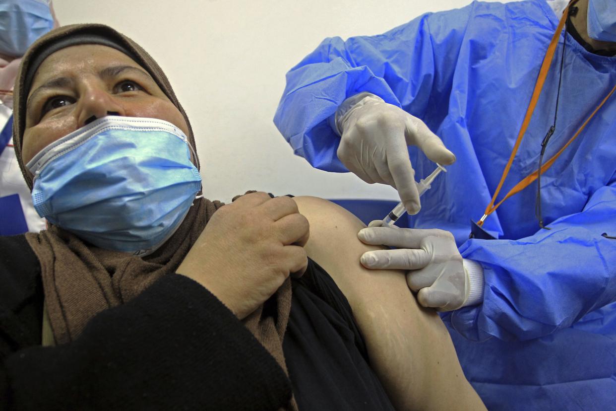 A woman receives the Sputnik-V COVID-19 vaccine at a vaccination center in Blida, south of Algiers, Algeria, Saturday, Jan. 30, 2021. The vaccines were delivered to the Boufarik military airport west of Algiers, Minister Amar Belhimeur said in a statement. He did not indicate how many arrived, though the government had said it had ordered the first batch of 500,000 Sputnik doses.