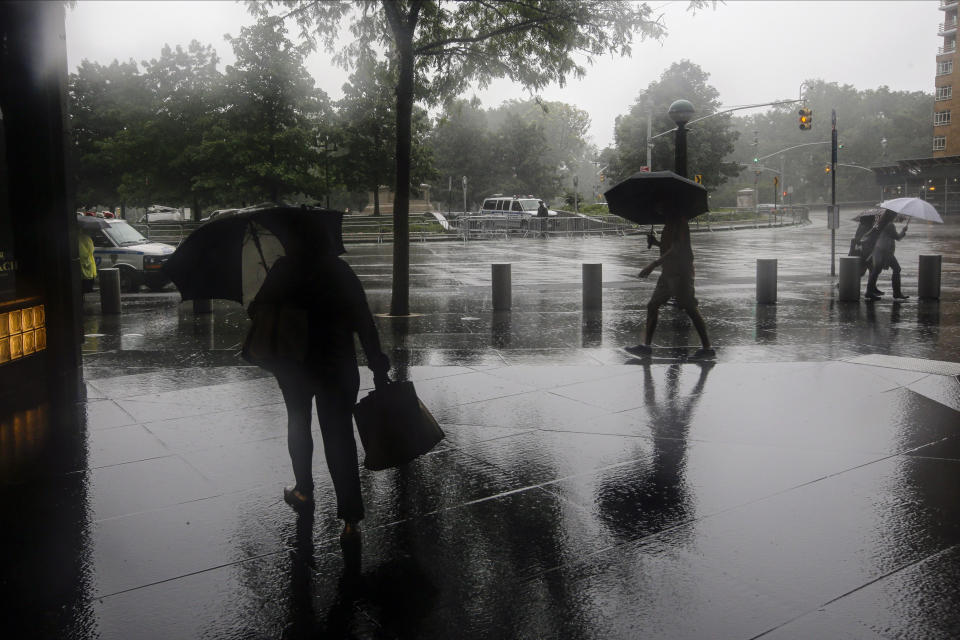 Pedestrians use umbrellas to protect themselves from inclement weather brought about by Tropical Storm Fay while walking near Columbus Circle Friday, July 10, 2020, in New York. Beaches closed in Delaware and rain lashed the New Jersey shore as fast-moving Tropical Storm Fay churned north on a path expected to soak the New York City region. (AP Photo/Frank Franklin II)