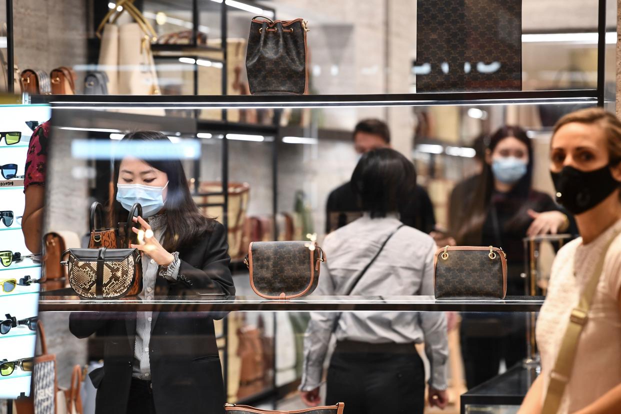 Customers wearing protective masks shop at the Galeries Lafayette on the first day of the reopening of the luxury general store, on May 30, 2020, in Paris, as France eases lockdown measures taken to curb the spread of the Covid-19 pandemic (novel coronavirus). (Photo by ALAIN JOCARD / AFP) (Photo by ALAIN JOCARD/AFP via Getty Images)