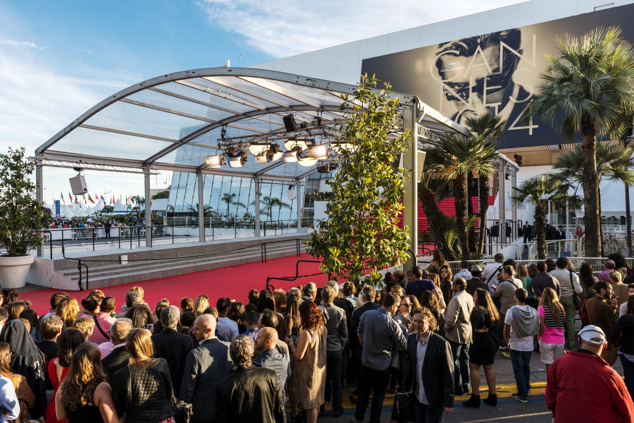 Cannes, France - May 24, 2014: Great Auditorium of the exit door at Cannes in France, the famous red carpeted stairs and crowd of people waiting at the gate output.