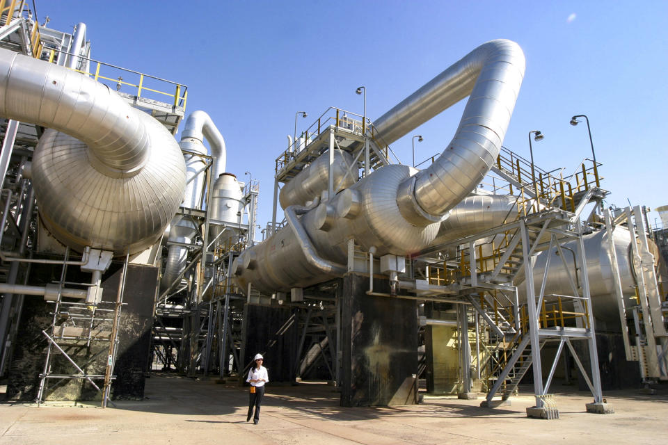 FILE - A worker walks among the Tengiz oil refinery utilities in Kazakhstan, Aug. 30, 2004. Contract workers at Kazakhstan's highest-producing oil field, Tengiz, have joined in protests that have taken place around the country. (AP Photo/Anatoly Ustinenko, File)