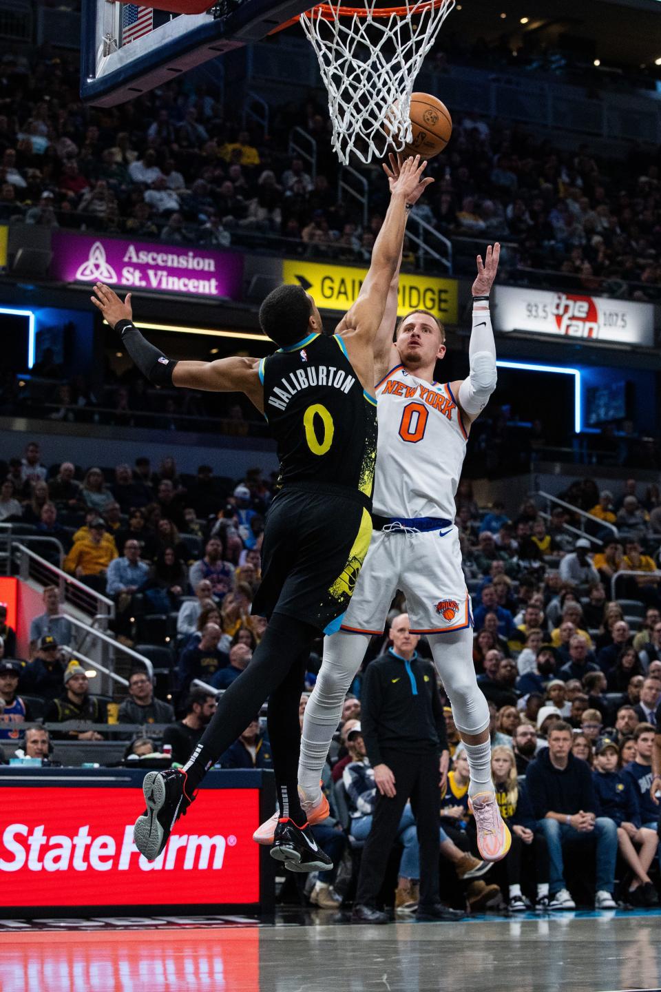 Dec 30, 2023; Indianapolis, Indiana, USA; New York Knicks guard Donte DiVincenzo (0) shoots the ball while Indiana Pacers guard Tyrese Haliburton (0) defends in the second half at Gainbridge Fieldhouse. Mandatory Credit: Trevor Ruszkowski-USA TODAY Sports