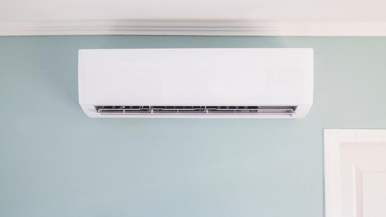  A wall mounted air conditioner on a blue wall 