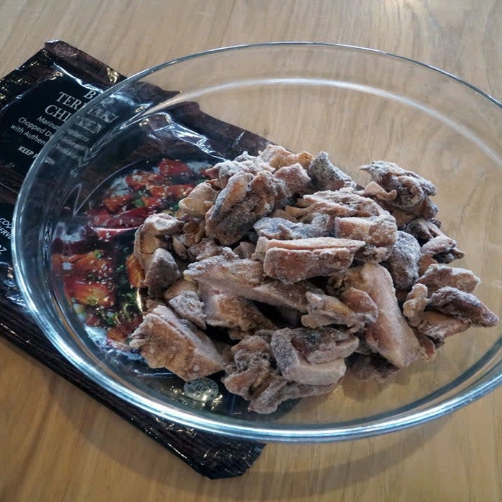 Frozen teriyaki chicken pieces in a glass bowl