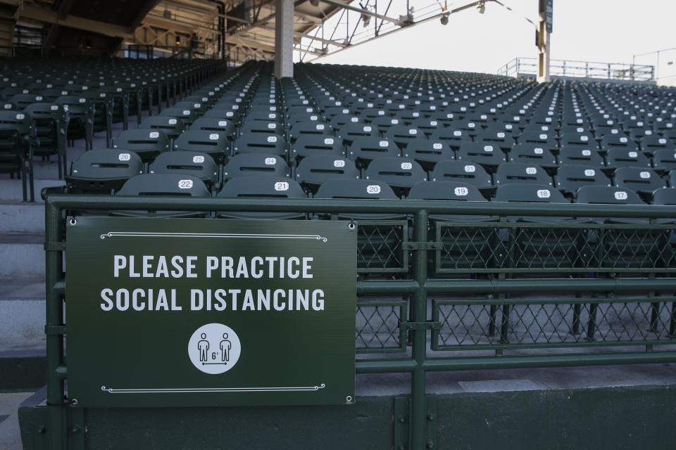A sign inside Wrigley Field requires guest to practice social distancing amid the coronavirus pandemic during Chicago Cubs baseball training camp on Sunday, July 5, 2020 in Chicago. (AP Photo/Kamil Krzaczynski)