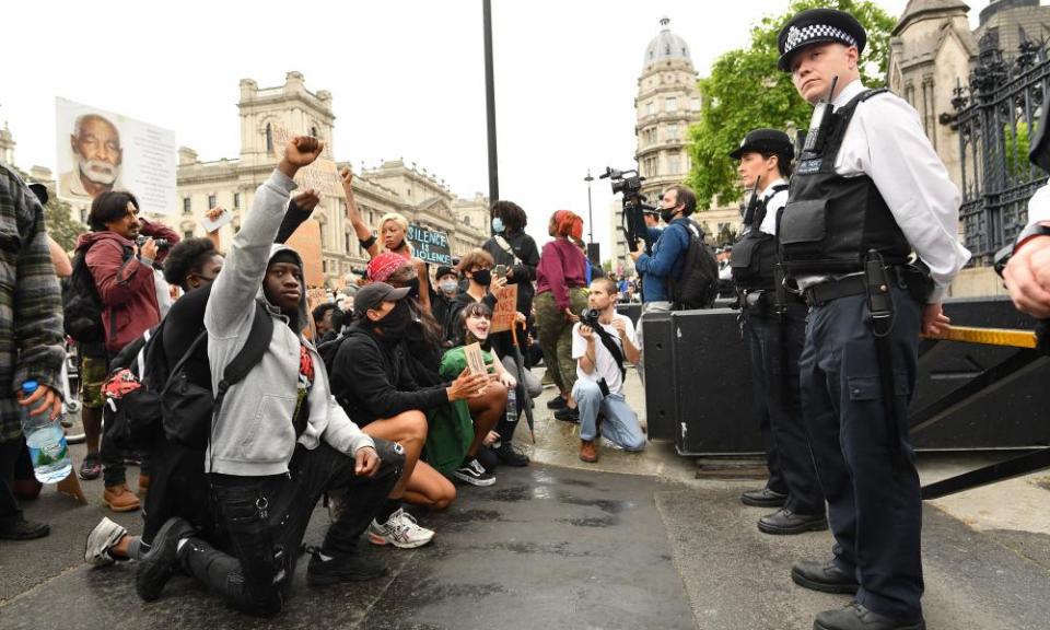 Protesters kneel in front of police during the Black Lives Matter protest.