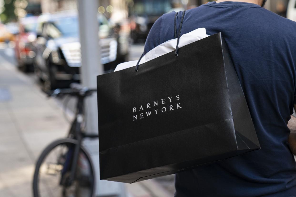 A man carries a Barneys New York shopping bag outside of the store in Midtown Manhattan, July 15, 2019 in New York City.