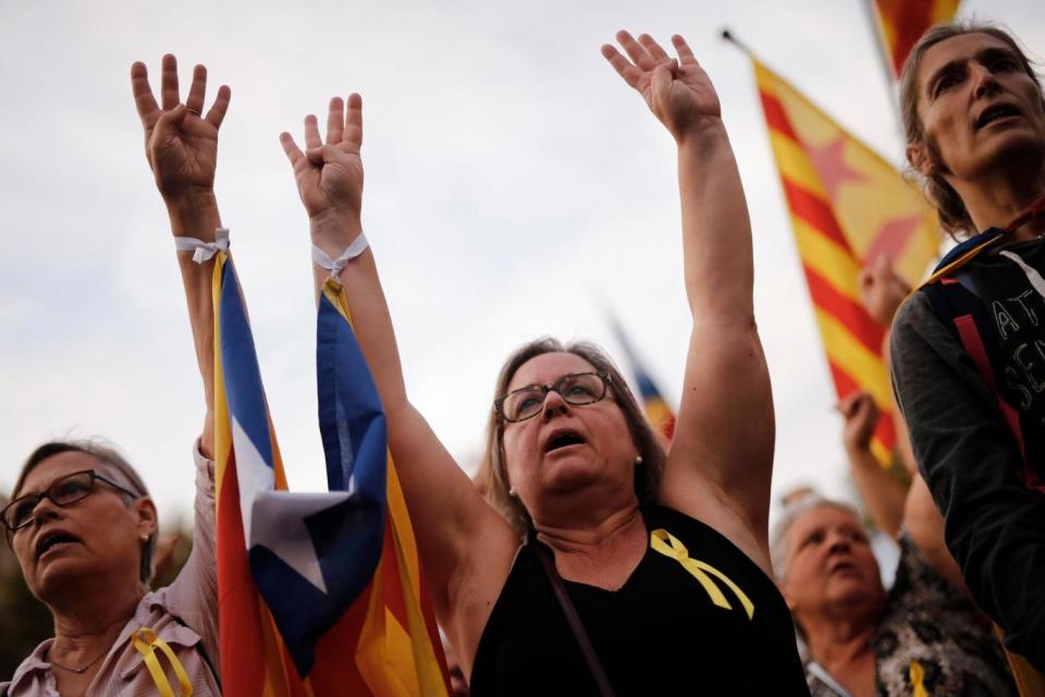 Protesters holding pro-independence Catalan Estelada flags raise their hands during a demonstration in Barcelona (AFP/Getty Images)