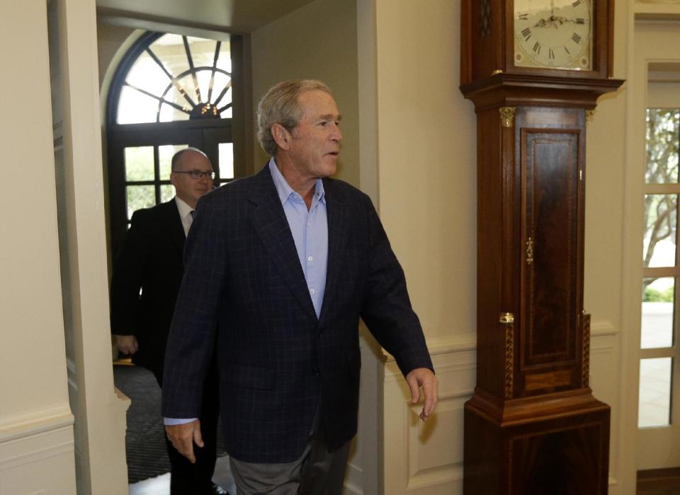 Former President George W. Bush walks into the oval office replica at the Bush Presidential Library as he surprises 43 Dallas-Fort Worth school children who were the first official guest of the museum on its' opening day Wednesday, May 1, 2013, in Dallas. (AP Photo/Tony Gutierrez)