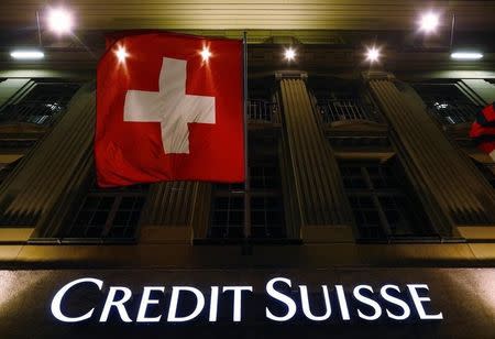 The logo of Swiss bank Credit Suisse is seen below the Swiss national flag at a building in the Federal Square in Bern May 15, 2014. REUTERS/Ruben Sprich